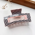 Detail of a pink and black houndstooth pattern hair claw clip on a textured white surface - Houndstooth Pink Base