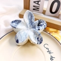 Detailed macro view of frangipani flower hair claw with blue marble texture on ceramic plate - 8cm UV Printed Plumeria - ABS Beige Style H