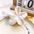 Close-up of frangipani flower hair claw with pink marble pattern on a ceramic dish - 8cm UV Printed Plumeria - ABS Beige Style Q