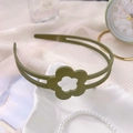 Vue détaillée d'un serre-tête floral vert foncé à texture mate sur un tissu blanc - Fleur Mate Vert Fruit