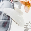 Detail of a creamy white glossy hair claw clip on a silver metal tray with floral decor - Jelly White