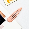 Close-up of a drop-shaped metal BB hair clip in soft peach pink with a smooth matte finish - Alloy / Pink