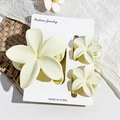 Detail of cream white matte flower hair claw clips set on rustic linen background - Matte Cream