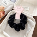 Premium black velvet oversized scrunchie hair tie with brand tag on studio background - Black