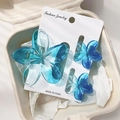 Detailed set of three gradient blue frangipani hair clips on a jewelry card - Transparent Blue