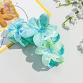 Detailed macro view of three plumeria flower hair claws with blue-green marble texture - 9.5cm Plumeria - Marble Jade Green