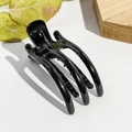 Gros plan d'une pince à cheveux noire brillante à trois dents sur fond texturé blanc - Pince Bec de Canard 8cm 3 Dents / Noir Brillant
