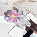Detail view of floral hair claws with pink graffiti petals and white floral patterns - Rose Red