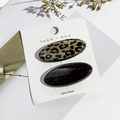 Detalle de pinzas para el pelo con estampado de leopardo y purpurina en cartón blanco - Elipse