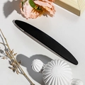Close-up of a matte black metal barrette with a sleek minimalist curved design and texture - 11.5cm Long Oval / Matte Black
