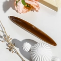 Close-up of a long amber tortoiseshell hair clip on a soft floral decorative background - 11.5cm Long Oval / Jelly Coffee