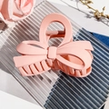 Close-up of pink bow hair claw clip with matte finish on a decorative glass tray - Matte Korean Pink