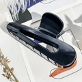 Details der glänzend schwarzen Haarklammer mit glatter Oberfläche und modernem Design - Schwarz