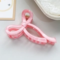 Close-up of pink marble texture hair claw clip with golden metal spring detail - Pink