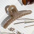 Macro detail of large marble brown hair claw clip on notebook with lifestyle decor - Milk Coffee