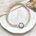 Detalle de gomas de pelo en espiral con acabado perlado sobre un plato decorativo de porcelana - Degradado Rosa Verde