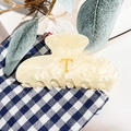 Vue détaillée de la pince à cheveux en acrylique crème marbré avec lettre T dorée - Blanc Crème - Lettre T