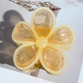 Close-up of a large amber-colored flower hair claw clip with a glossy translucent finish - Orange with Yellow Edge