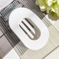 Detail view of large white glossy oval hair claw clip with minimalist hollow design - Glossy White