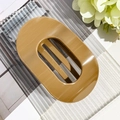 Close-up of a glossy coffee-colored oval hair claw clip with a hollow design and strong grip - Glossy Milk Coffee