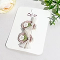 Détail de barrettes à fleurs crochetées à la main avec n&oelig;ud en résille rose sur carte - Fleur de Perle