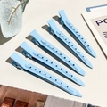 Dettaglio di cinque fermagli per capelli in metallo azzurro opaco con fori decorativi - 9cm / 5 Pezzi / Celeste