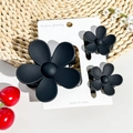Detailed view of matte black flower hair claws in three-piece set on a card - Matte Black