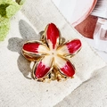 Macro detail of enamel plumeria flower hair claw with gold metallic edges and red gradient - 3cm Rose Red Beige Heart Frangipani Metal Claw