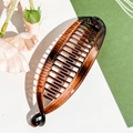 Close-up detail of tortoiseshell banana hair clip with secure double-sided interlocking teeth - Plastic/Resin / 11.5cm / Glossy Amber Coffee