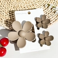 Three matte flower hair claws on a jewelry card with decorative floral background - Matte Milk Coffee