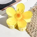 Detailed view of yellow plumeria flower hair claw clip on textured white leather - Plastic/Resin / Gradient Milky Yellow