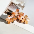 Three sizes of orange plumeria hair claws with marble acetate texture for elegant styling - Colorful Orange