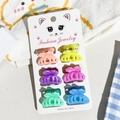 Detailed view of six colorful bow mini hair claws with glitter finish on a cat display card - Small / Marble Pumpkin Style