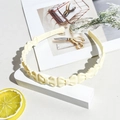 Detail view of cream wavy headband with small bows and non-slip inner teeth structure - Matte Bowknot Headband - Off-white