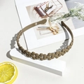 Detail showing matte brown flower chain wavy headband on a minimalist white display - Matte Hollow Flower Headband - Milk Coffee