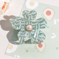 Close-up of floral acetate hair claw with mint green checkered pattern and center pearl - Fruit Green