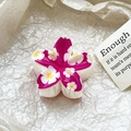 Macro view of white frangipani hair claw with deep rose printing and floral details - Dark Rose Small Flower Style (103-1)