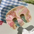 Vue détaillée de la grande pince à cheveux marbrée rose et verte avec bords ondulés - Rose Chair