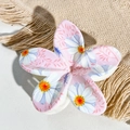 Close-up of pink frangipani hair claw clip with white daisy print on beige linen fabric - Pink White Daisy Texture Style / ABS