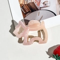 Close-up of translucent pink puppy-shaped hair claw clip with smooth acrylic finish - Pink Dog Style