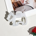 Close-up of white acetate dog-shaped hair claw clip on a textured background - Beige Dog Style