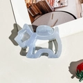 Detail of the sky blue schnauzer shaped hair claw clip on a white textured surface - Blue Dog Style