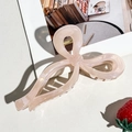 Detailed view of the large pearlescent pink bow hair claw clip with golden metal spring - Pink Bow Style