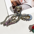 Close-up of a large gunmetal bow-shaped hair claw clip with a glossy metallic finish - Gray Bow Style