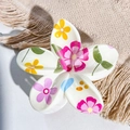 Detail view of Frangipani hair claw clip with floral UV print on beige textured fabric - Cream White Pink Yellow Flower Leaf Style / ABS