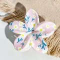 Detail shot of a pink floral hair claw clip with white daisy print on soft beige fabric - Pink White Daisy Blue Leaf Style / ABS