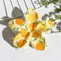 Detail view of tropical plumeria hair claw clip with fresh orange and leaf UV print - Orange Print (147-1)