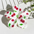 Macro shot of flower hair claw clip with red cherry prints on a glossy white finish - Cherry Print (147-3)
