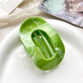 Green and white marble texture oval hair claw clip displayed on a white ceramic plate - 10cm Round Clip - Marble Fruit Green