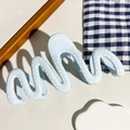 Dettaglio molletta capelli ondulata blu chiaro con motivo cucito bianco e finitura opaca - Stile a Onda Azzurro